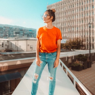 Sophie standing on a balcony looking over apartment buildings.